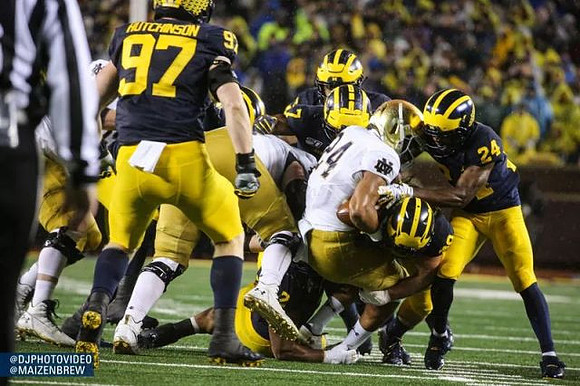 Aidan Hutchinson (97), Khaleke Hudson (7), Jordan Glasgow (29), and Lavert Hill (24)