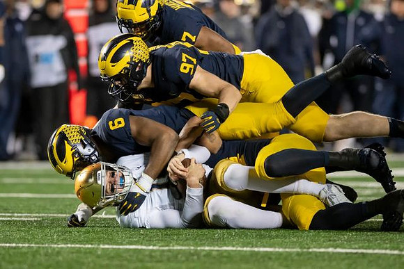 Josh Uche (6), Aidan Hutchinson (97), and Khaleke Hudson (7)
