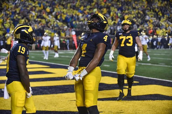 Mike Sainristil (19), Nico Collins (4), and Jalen Mayfield (73)