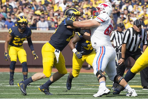 Tyree Kinnel (23), Chase Winovich (15), and Devin Gil (36)
