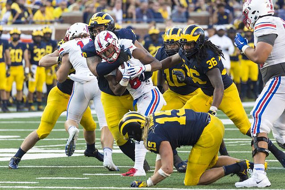 Chase Winovich (15), Bryan Mone (90), Devin Bush (10), and Devin Gil (36)