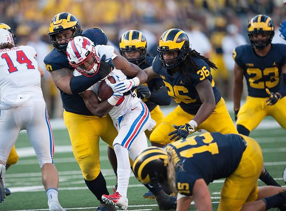 Bryan Mone (90), Chase Winovich (15), Devin Gil (36), and Tyree Kinnel (23)