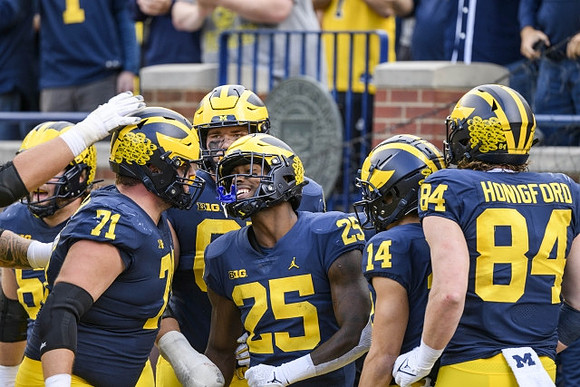 Andrew Stueber (71), Hassan Haskins (25), Roman Wilson (14), and Joel Honigford (84)
