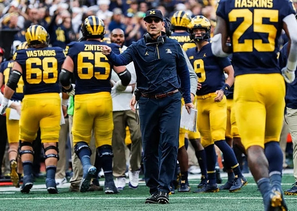 Andrew Vastardis (68), Zak Zinter (65), Jim Harbaugh, J.J. McCarthy (9), and Hassan Haskins (25)