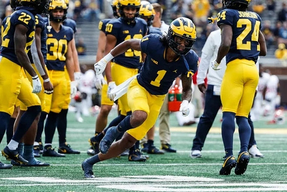 Ja'Den McBurrows (1), George Johnson (24), and Michigan Team