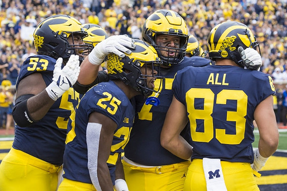 Trente Jones (53), Hassan Haskins (25), Trevor Keegan (77), and Erick All (83)