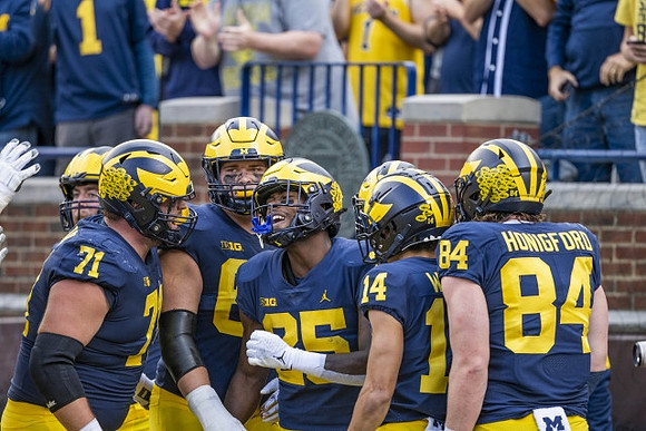 Andrew Stueber (71), Hassan Haskins (25), Roman Wilson (14), and Joel Honigford (84)
