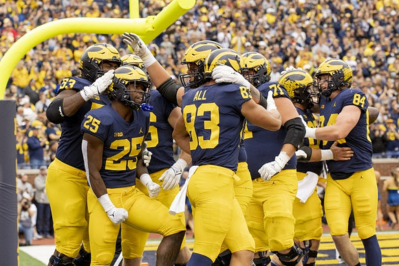 Trente Jones (53), Hassan Haskins (25), Erick All (83), Andrew Stueber (71), and Joel Honigford (84)