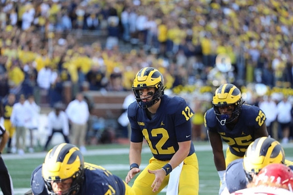 Andrew Stueber (71), Cade McNamara (12), and Hassan Haskins (25)