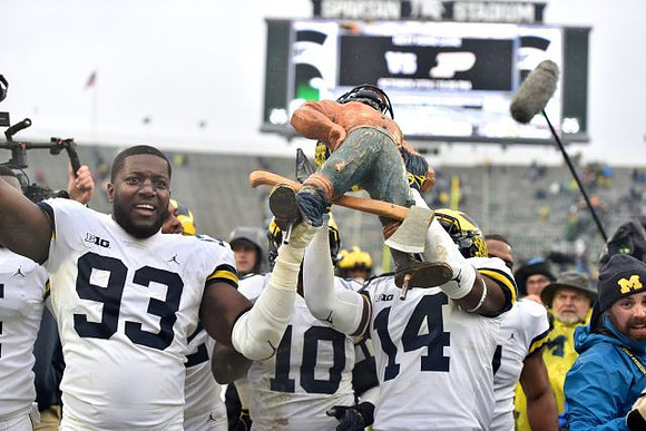 Lawrence Marshall (93), Devin Bush (10), Josh Metellus (14), and Paul Bunyan Trophy