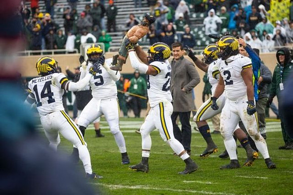 Josh Metellus (14), Aubrey Solomon (5), Tyree Kinnel (23), Carlo Kemp (2), and Paul Bunyan Trophy