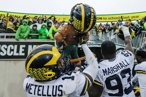 Josh Metellus (14), Lawrence Marshall (93), and Paul Bunyan Trophy