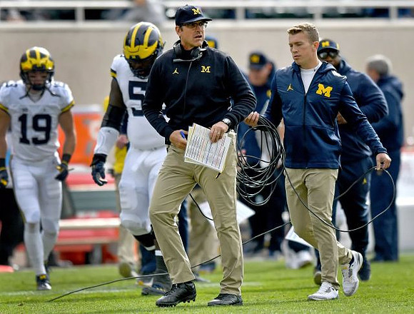 Kwity Paye (19), Michael Dwumfour (50), and Jim Harbaugh