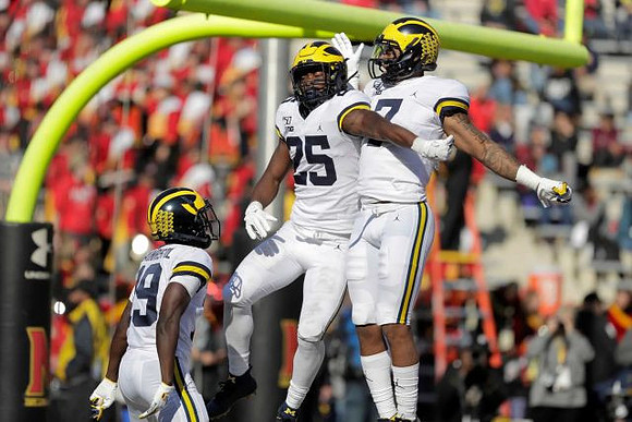 Mike Sainristil (19), Hassan Haskins (25), and Tarik Black (7)