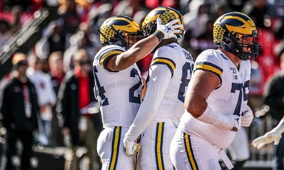 Zach Charbonnet (24), Nick Eubanks (82), and Jon Runyan Jr. (75)