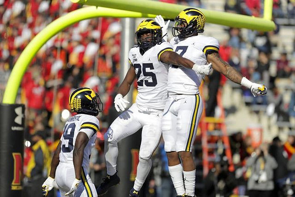 Mike Sainristil (19), Hassan Haskins (25), and Tarik Black (7)