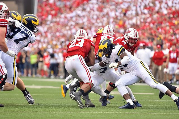 Aidan Hutchinson (97), Khaleke Hudson (7), and Josh Metellus (14)