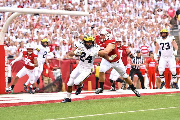 Shea Patterson (2), Zach Charbonnet (24), and Jalen Mayfield (73)