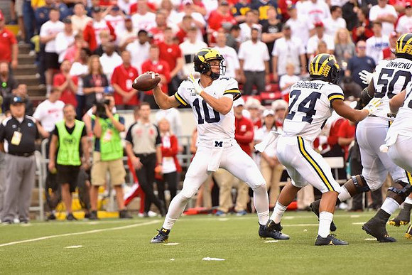 Dylan McCaffrey (10), Zach Charbonnet (24), and Michael Onwenu (50)