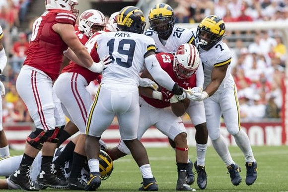 Kwity Paye (19), Brad Hawkins (20), and Khaleke Hudson (7)