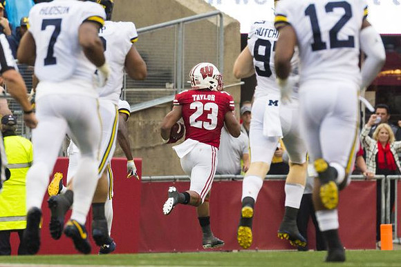 Khaleke Hudson (7), Aidan Hutchinson (97), and Josh Ross (12)