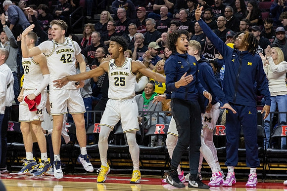 Jace Howard (25) and Michigan Team