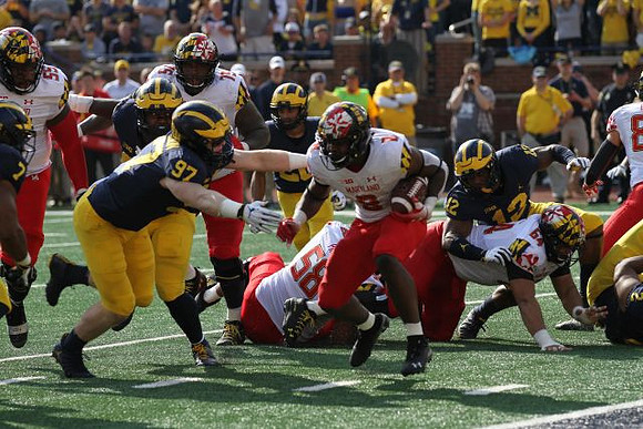 Khaleke Hudson (7), Aidan Hutchinson (97), and Josh Ross (12)