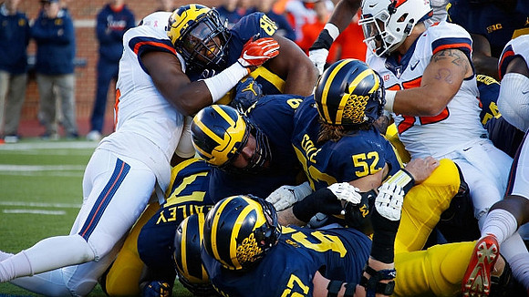 Tyrone Wheatley Jr. (17), Kyle Kalis (67), Mason Cole (52), Henry Poggi (19), Khalid Hill (80), and Ben Bredeson (74)