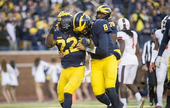 Karan Higdon (22), John O'Korn (8), and Juwann Bushell-Beatty (76)