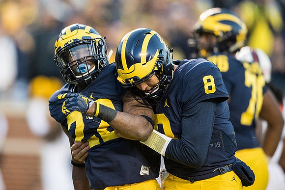 Karan Higdon (22), John O'Korn (8), and Juwann Bushell-Beatty (76)