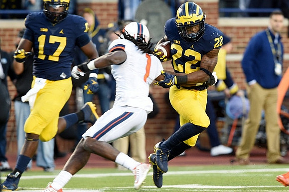 Tyrone Wheatley Jr. (17) and Karan Higdon (22)