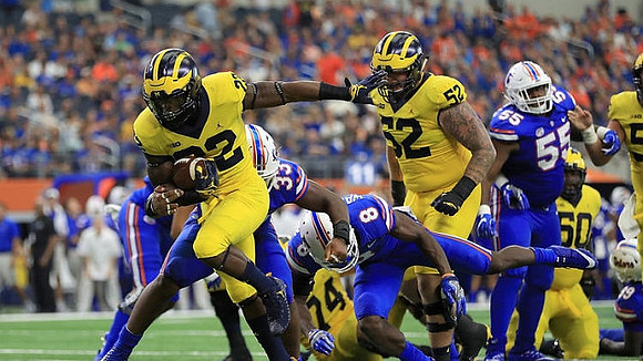Karan Higdon (22), Ben Bredeson (74), Mason Cole (52), and Michael Onwenu (50)