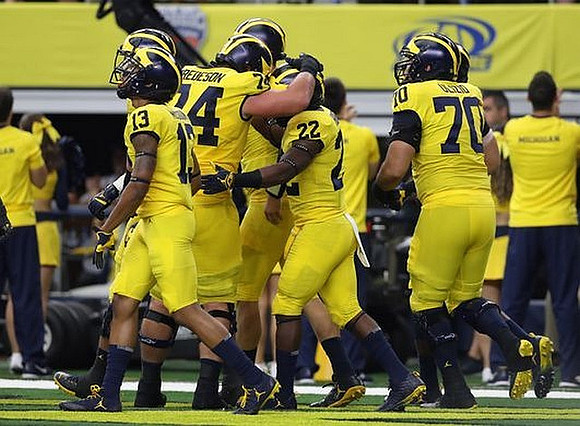 Eddie McDoom (13), Ben Bredeson (74), Karan Higdon (22), and Nolan Ulizio (70)