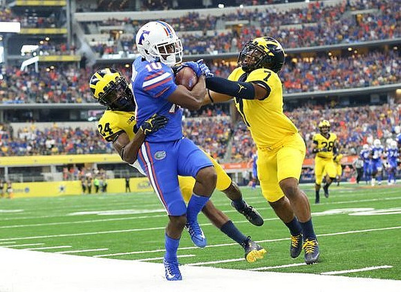 Lavert Hill (24), Khaleke Hudson (7), and Brandon Watson (28)