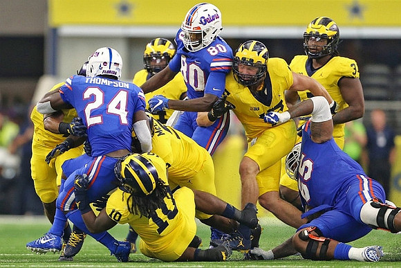 Devin Bush (10), Mike McCray (9), and Chase Winovich (15)
