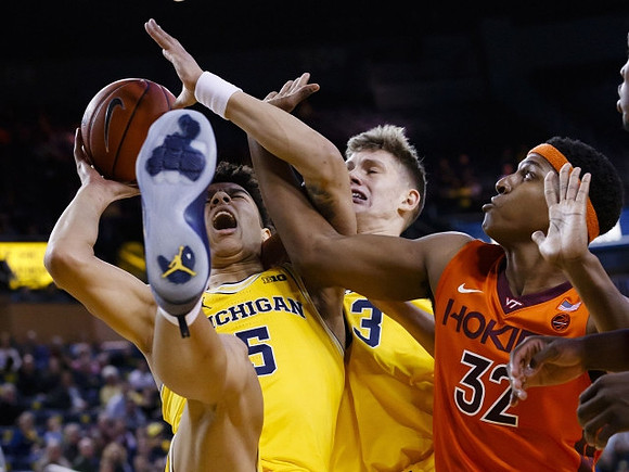 D.J. Wilson (5) and Moritz Wagner (13)