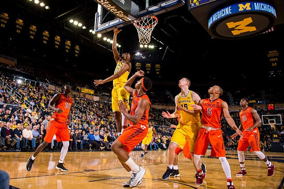 Zak Irvin (21), Derrick Walton Jr. (10), and Jon Teske (15)