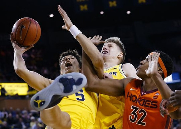 D.J. Wilson (5) and Moritz Wagner (13)