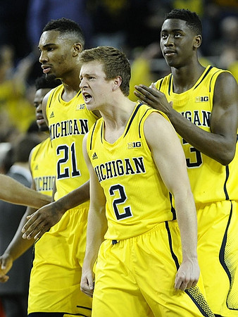 Zak Irvin (21), Spike Albrecht (2), and Caris LeVert (23)