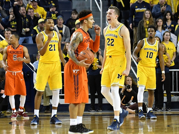 Zak Irvin (21), Duncan Robinson (22), and Derrick Walton Jr. (10)