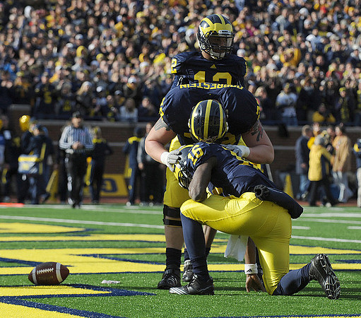 Denard Robinson (16), Perry Dorrestein (79), and Roy Roundtree (12)