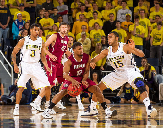 Trey Burke (3) and Jon Horford (15)