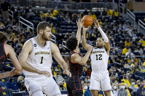 Hunter Dickinson (1) and DeVante' Jones (12)