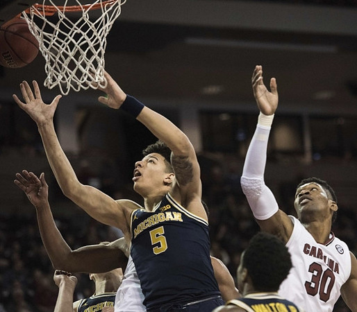 D.J. Wilson (5) and Derrick Walton Jr. (10)