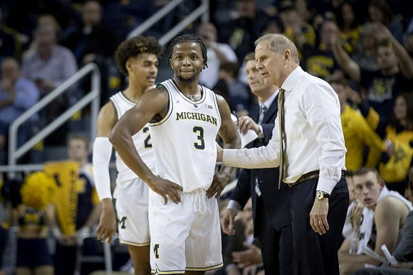 Jordan Poole (2), Zavier Simpson (3), and John Beilein