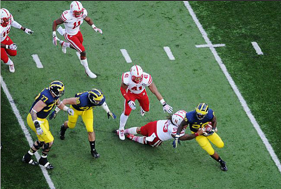 Taylor Lewan (77), Jake Butt (88), and Fitzgerald Toussaint (28)