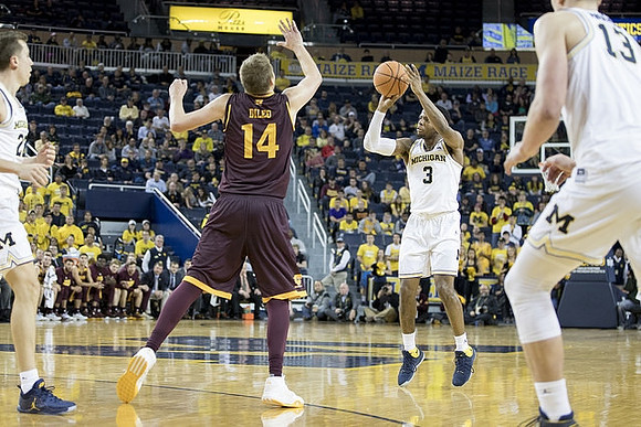 Duncan Robinson (22), Zavier Simpson (3), and Moritz Wagner (13)