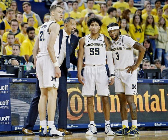 Franz Wagner (21), Juwan Howard, Eli Brooks (55), and Zavier Simpson (3)