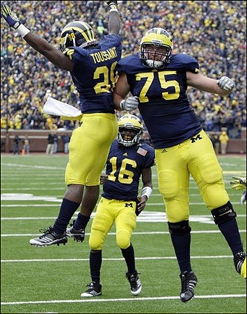 Fitzgerald Toussaint (28), Denard Robinson (16), and Michael Schofield (75)