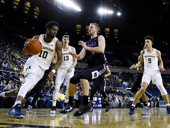 Derrick Walton Jr. (10), Moritz Wagner (13), and D.J. Wilson (5)
